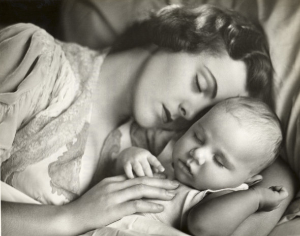 Mother holding infant in bed