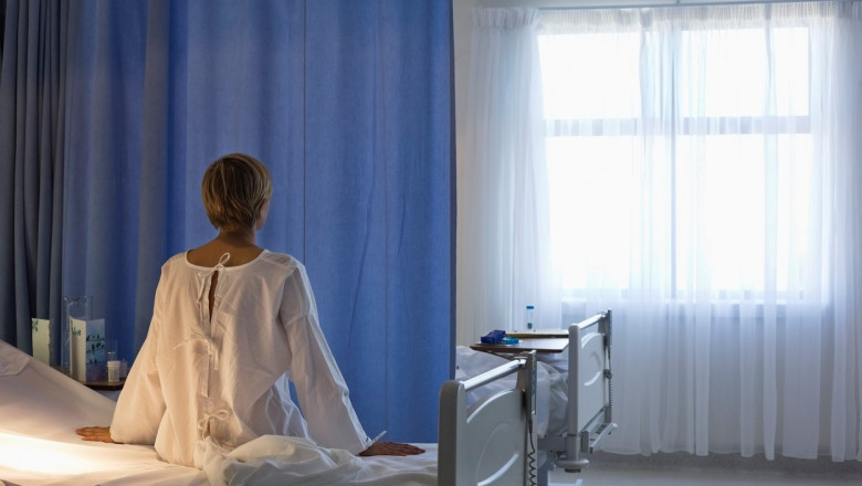 femeie cu spatele care sta pe marginea patului in spital