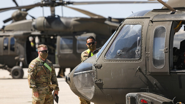 Militari americani lângă elicoptere.