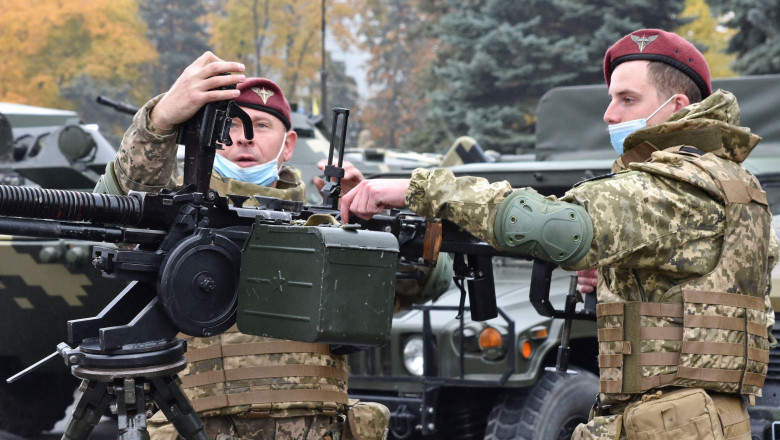 Doi solda'i Ucraineni care efectuează un exerci'iu demonstrativ de âncărcare a unei arme de luptă