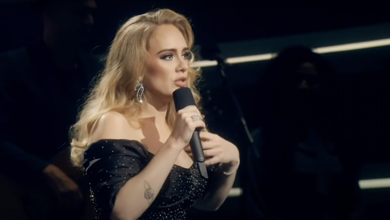 adele vorbeste aratand spre sine