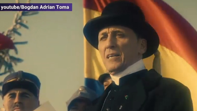 Scenă din filmul „Cardinalul”. un barbat cu palarie tine un discurs cu un steag in spate