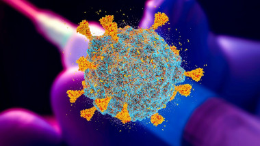 concept grafic cu un coronavirus avand pe fundal o seringă cu vaccin