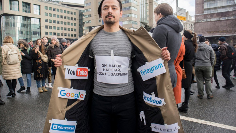 protestatar rus pentru libertatea internetului purtand insemnele FB, youtube, google, wikipedia