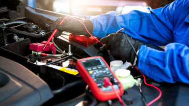 un tehnician verifica voltajul unei baterii la o masina electrica