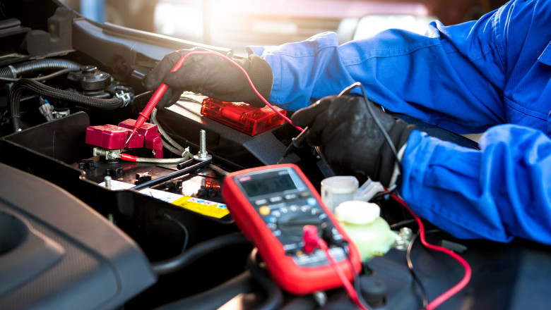 un tehnician verifica voltajul unei baterii la o masina electrica