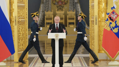 Președintele rus Vladimir Putin tine un discurs cu militari cu uniforme de gala in spate