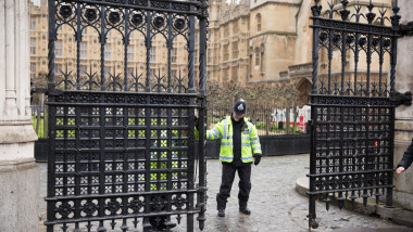 Un polițist londonez închide poarta la Parlamentul britanic.