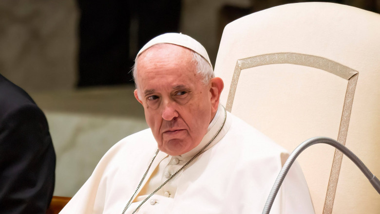 Papa Francisc stă pe scaun.