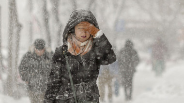 femeie pe strada in ninsoare