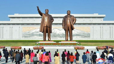 people offering flowers to the statue of President Kim Il Sung and Chairman Kim Jong Il on Mansu Hill in Pyongyang