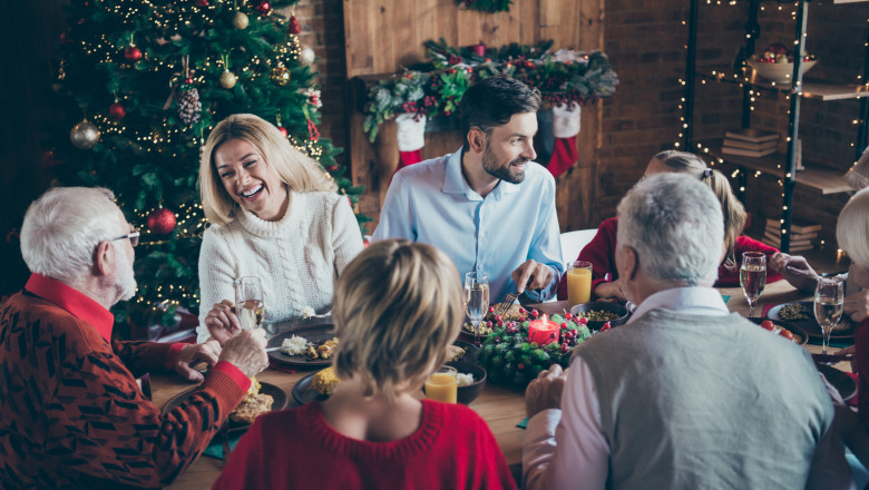 familie care sta la masa de craciun