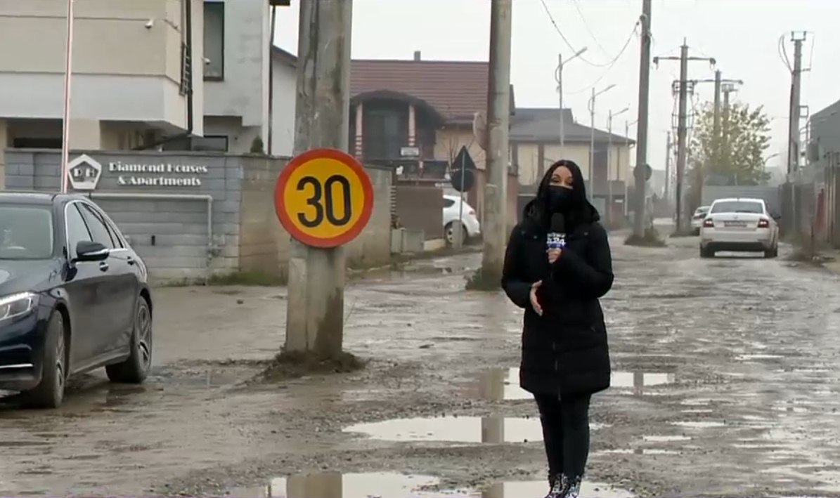 VIDEO. Stâlpi în mijlocul străzii, cratere pline cu apă și trotuare neterminate. Cum arată străzile dintr-un oraș de lângă București