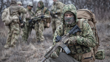 Militari înarmați, la marginea unei păduri