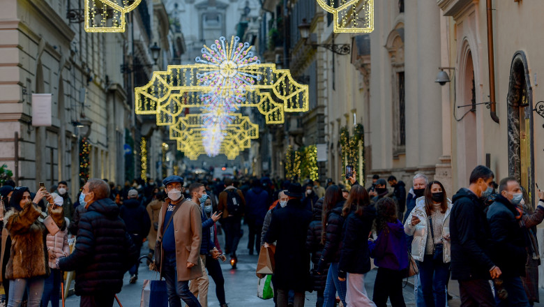 oameni pe stradă cu luminite in italia
