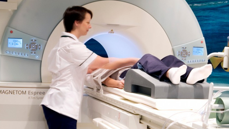 Un cadru medical așază un pacient într-un aparat RMN.
