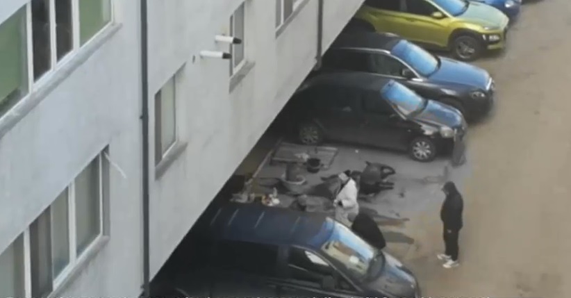Mai mulți bărbați au tăiat un porc în parcarea unui bloc și l-au pârlit între mașini