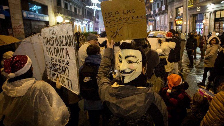 protest impotriva restrictiilor in barcelona, oameni cu masti guy si pancarte