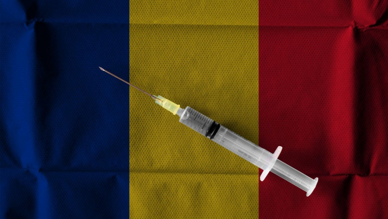 O seringă așezată pe un drapel al României.