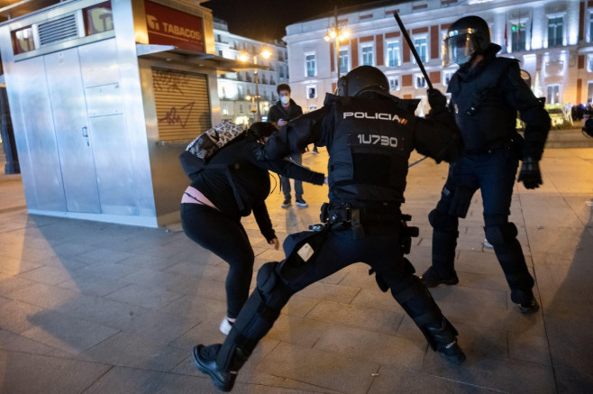 Madrid, Spain. 17th Feb, 2021. Riot police beating a woman during clashes in a demonstration against the imprisonment of Spanish rapper Pablo Hasel for some song lyrics and tweets criticizing the Spanish Monarchy. Credit: Marcos del Mazo/Alamy Live News