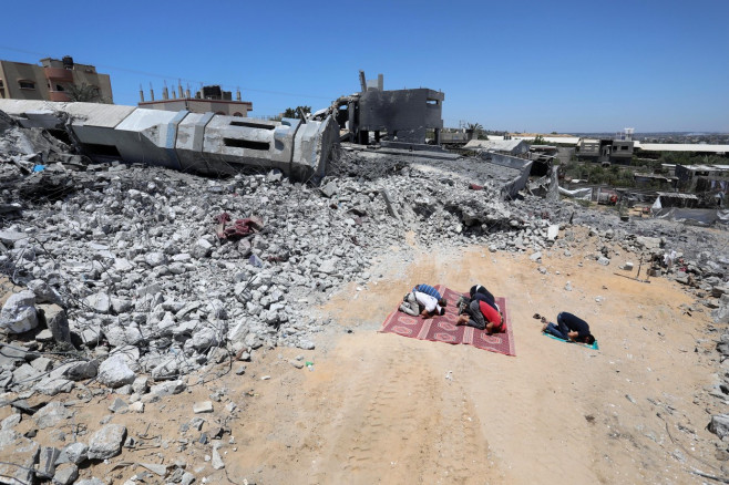 Palestinian Muslim worshippers pray near the rubble of a mosque which was destroyed by Israeli air strikes in Beit Lahia, in the northern Gaza Strip, Beit Lahia, Gaza Strip, Palestinian Territory - 27 May 2021