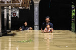 Familie din indonezia care încearcă să iasă dintr-o zonă inundată