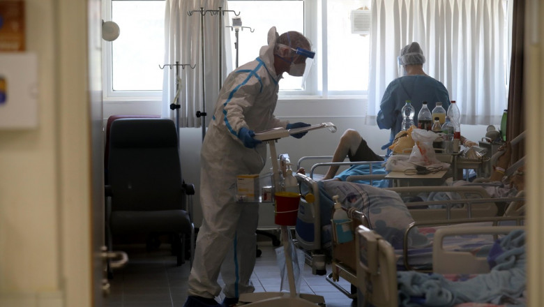 medic în costum de protecție vorbește cu pacienți Covid într-un salon de la un spital din Israel
