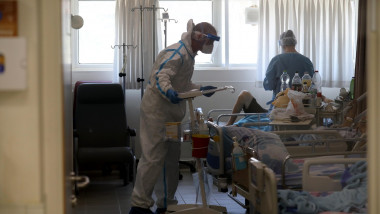 medic în costum de protecție vorbește cu pacienți Covid într-un salon de la un spital din Israel