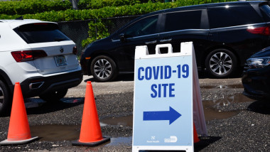 Indicator pentru un centru de testare Covid în Florida, Statele Unite, lângă un jalon de circulație și mai multe mașini parcate