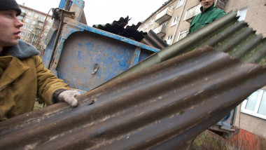 Oameni care adună resturi de acoperiș după o furtună în Riga.