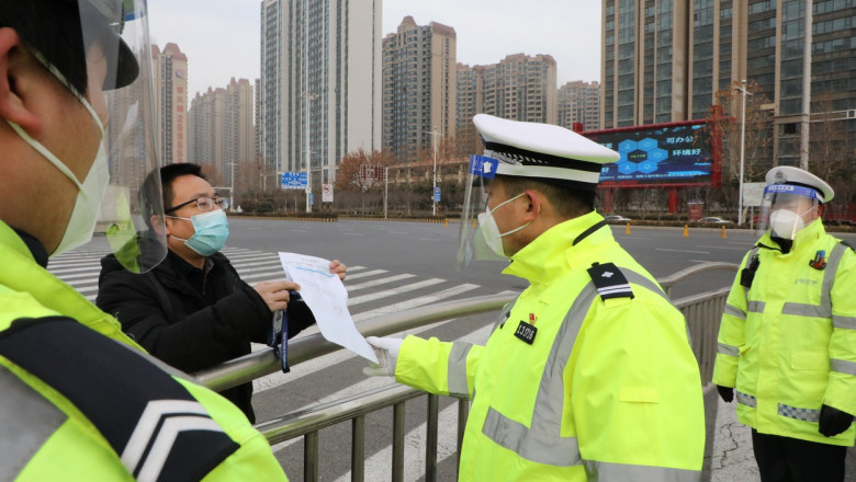 barbat caruia politistii chinezi ii verifica pe strada o declaratie scrisa