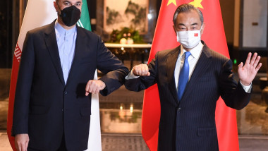 Ministrul chinez de externe Wang Yi şi omologul său iranian Hossein Amir-Abdollahian pozaza salutandu-se cu cotul