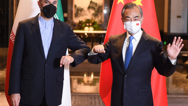 Ministrul chinez de externe Wang Yi şi omologul său iranian Hossein Amir-Abdollahian pozaza salutandu-se cu cotul