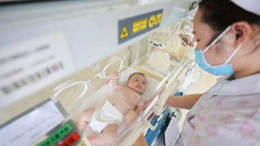 nou nascut si asistenta medicala cu masca la o maternitate din china