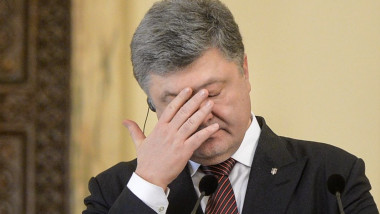 Petro Poroșenko își pune mână pe față.