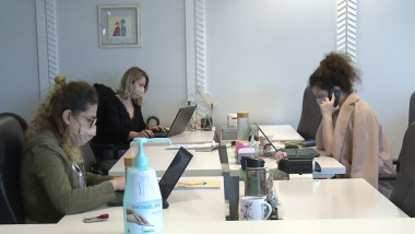 Angajate care lucrează la laptop, într-un birou.