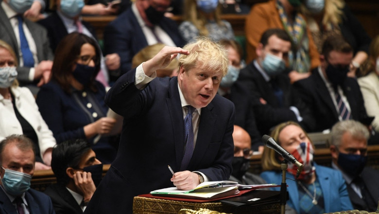 boris johnson gesticuleaza in parlamentul britanic, inconjurat de parlamentari