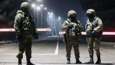 ALMATY, KAZAKHSTAN - JANUARY 14, 2022: A Russian peacekeeper (L) and Kazakh servicemen stand guard as the CSTO peacekeeping forces assemble for departure from Almaty International Airport. The Collective Security Treaty Organisation proceeds with a phased