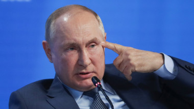 Vladimir Putin, cu degetul la cap, la o conferință de presă.