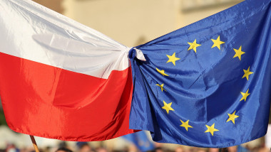Flags of European Union and Poland tied together hold by people protesting in massive public demonstration to support Poland's membership in EU