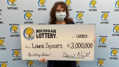 Laura Spears cu masca pe figura și premiul ei de 3 milioane de dolari