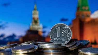 moneda ruseasca pe o gramada de monede avand in spate kremlinul
