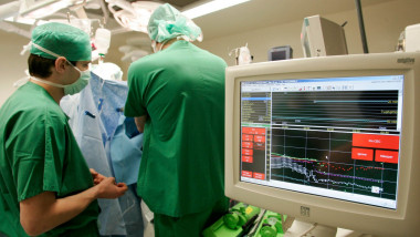 doctori opereaza pacient, monitor cu datele vitale ale pacientului