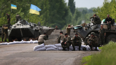 Militari ucraineni se odihnesc pe un drum.