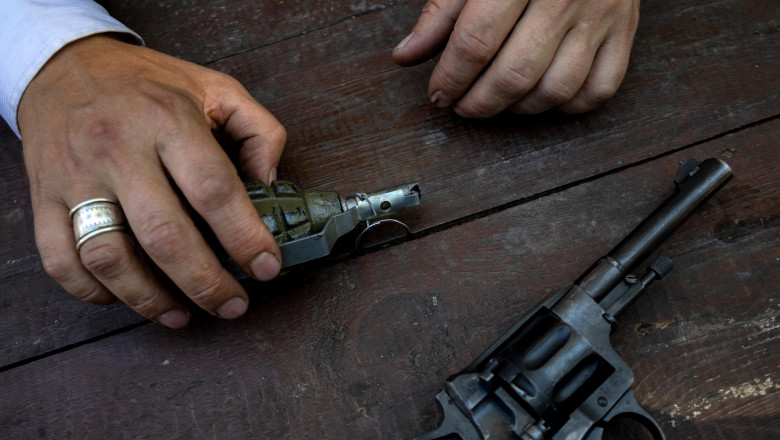 A bandit with a grenade sits at a wooden table