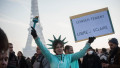 femeie costumata statuia libertatii protesteaza anti restrictii covid la pris, turnul eiffel pe fundal