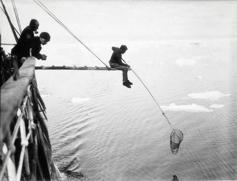 Crew members fishing from the deck of Endurance suring Ernest Sjackleton's epic Antarctica voyage in 1912
