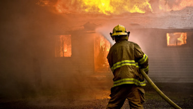 un pompier stinge un incendiu la o casa