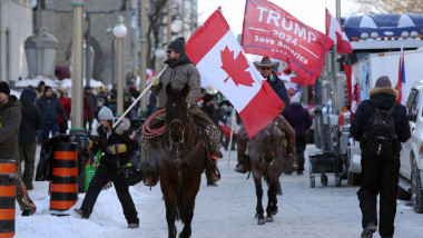 protestatari calare in canada, cu steagul canadian si un steag cu trump