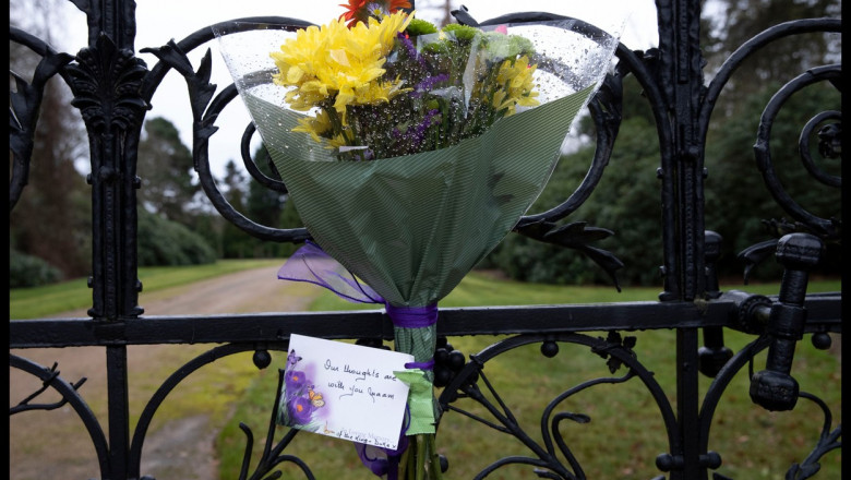 buchet de flori si o felicitare prinse de poarta resedintei de la Sandrigham a Reginei Elisabeta a II-a de unul dintre admiratori